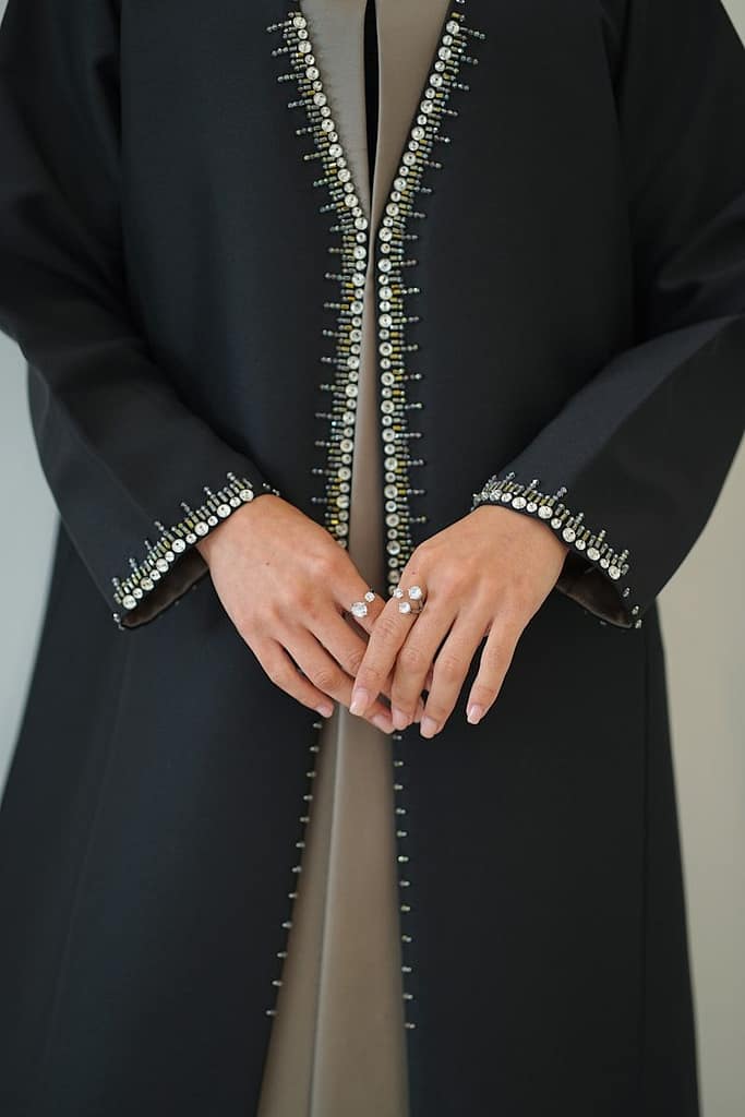 Black abaya with pearl and bead embellishments on sleeves.